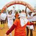 A Color Run volunteer sprays participants with orange powder on Saturday, May 11. Daniel Brenner I AnnArbor.com
